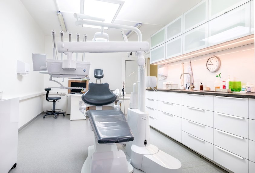 A dentist's office with a chair and equipment