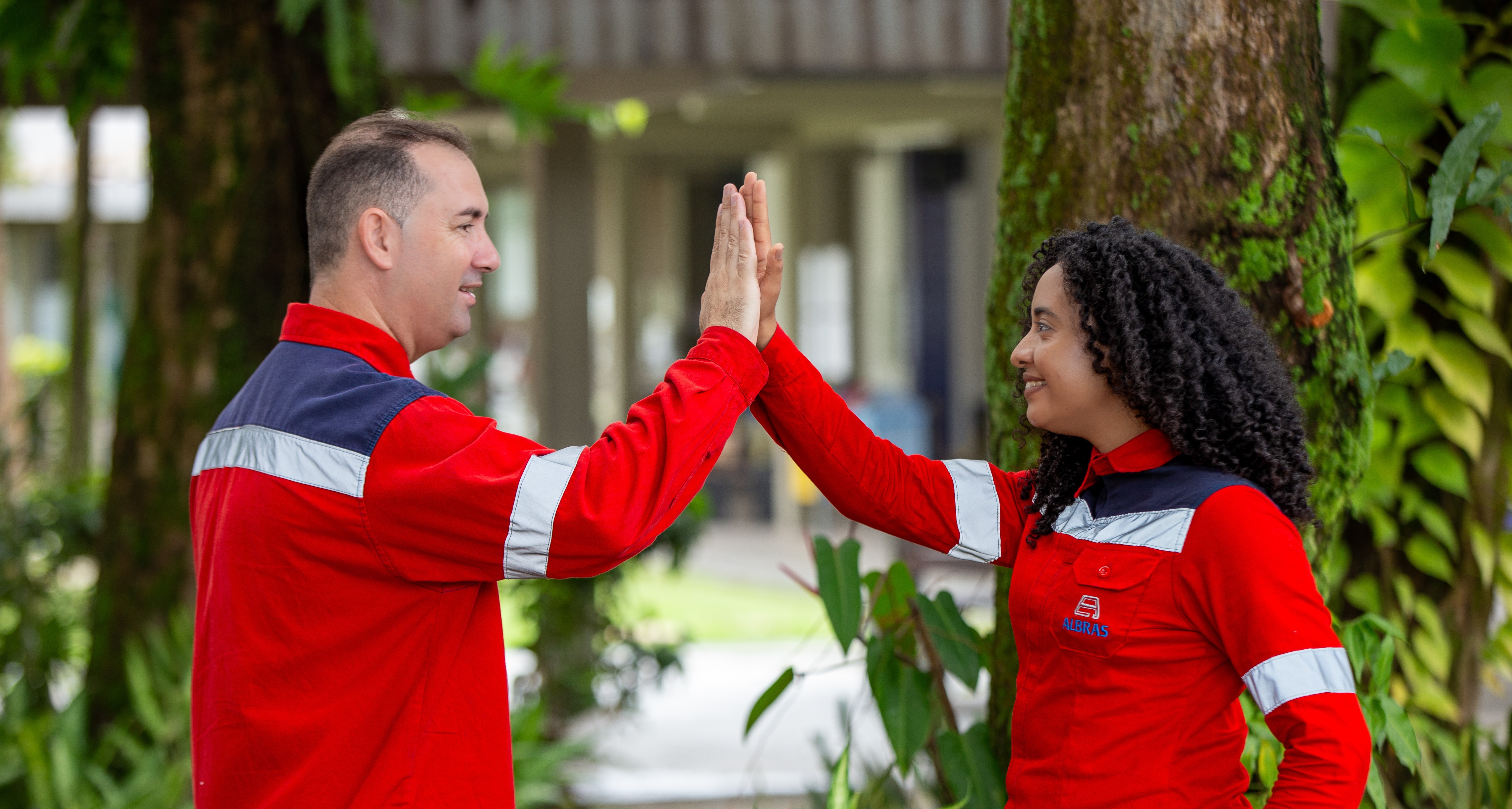a man and woman in red uniforms giving each other high fiving