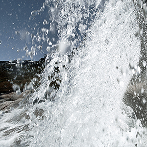 a large waterfall with snow on the sides