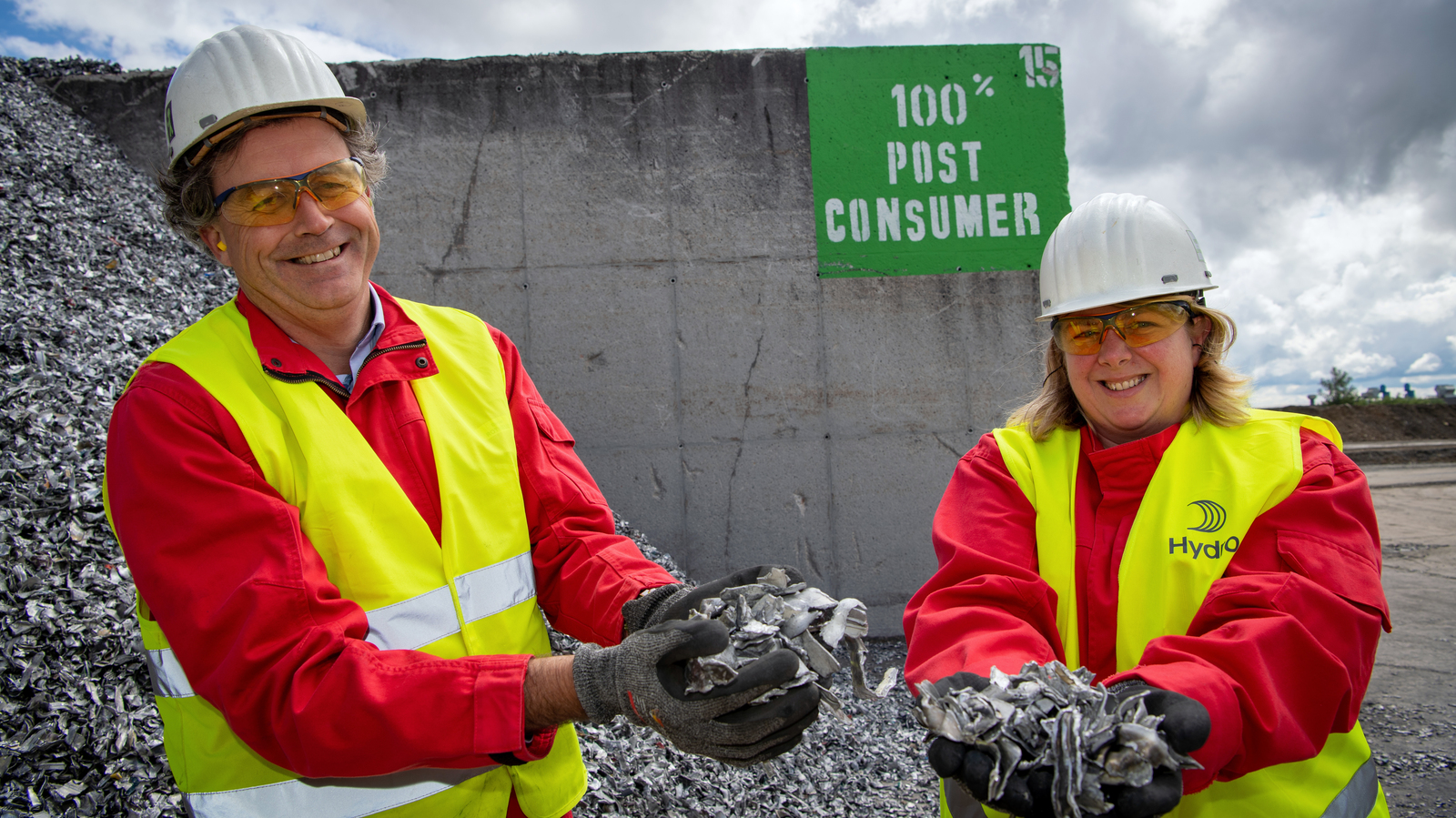 a man and woman wearing hard hats and holding a large rock