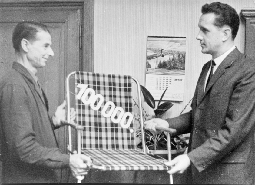 two men holding a chair